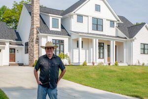 A Man in a Cow Boy Hat Standing in Front of a House