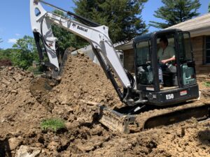 An Excavator Taking Up Piles of Soil